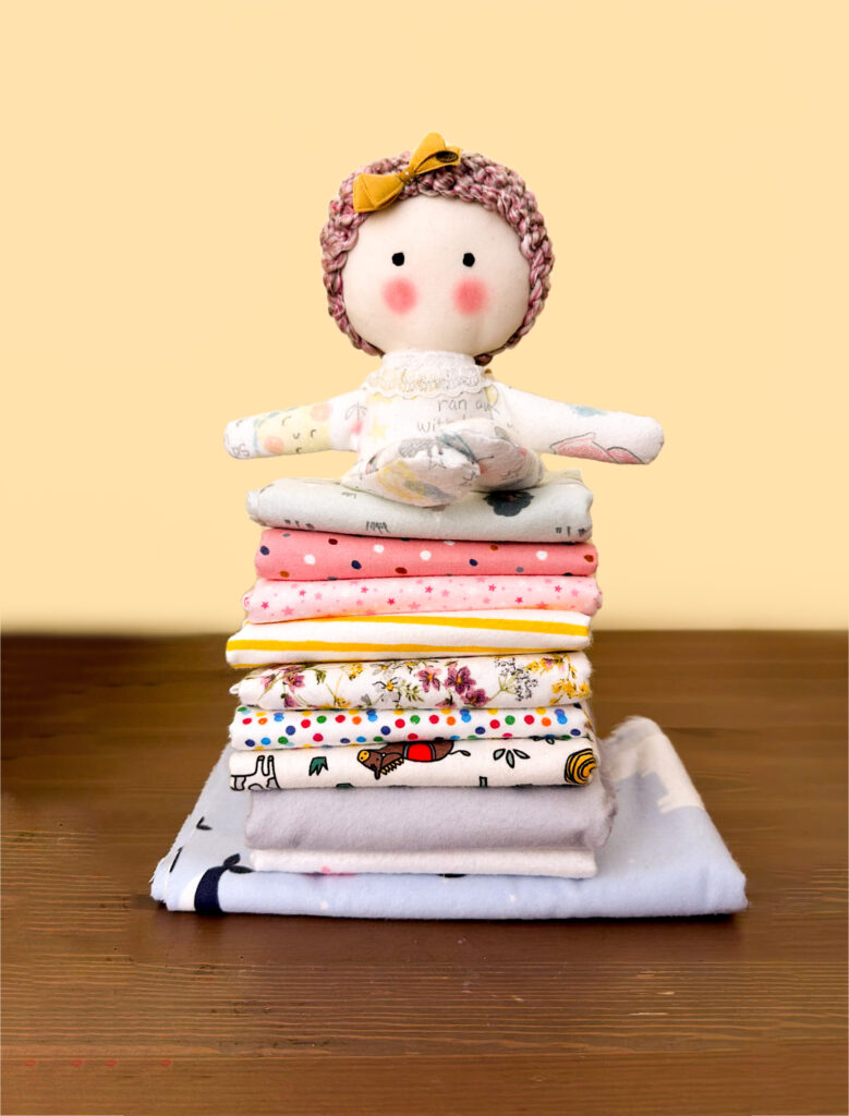 A doll above peaces of fabric